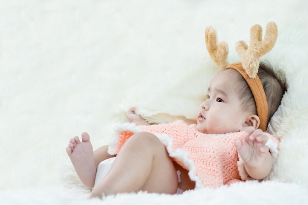 selective focus face of Asian baby and costume of reindeer