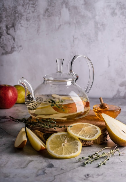 Messa a fuoco selettiva, tè appena preparato in una teiera trasparente, con frutta e bacche fresche. tè in foglia e spezie. natura morta. per pubblicità e menu