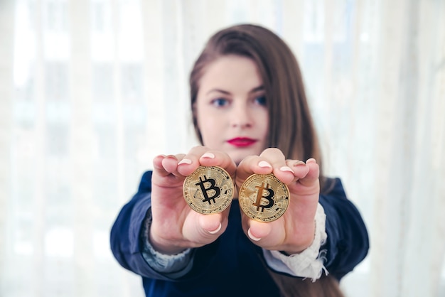 Photo selective focus on golden bitcoin in woman hands