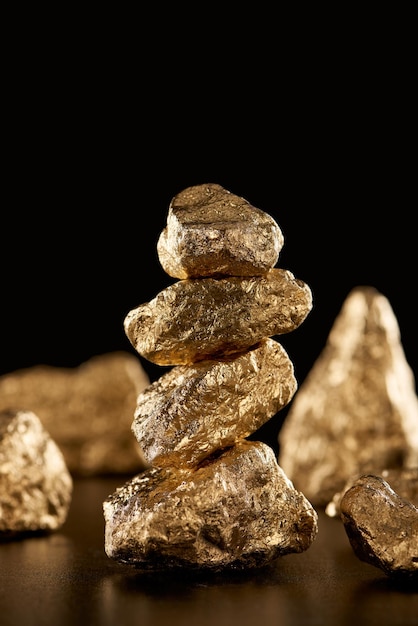 Selective focus of golden shiny stones isolated on black with copy space