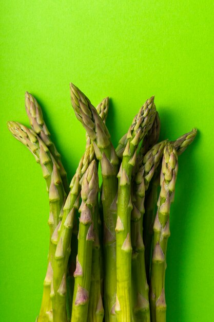 Selective focus, green asparagus pods on a uniform background, vertical position