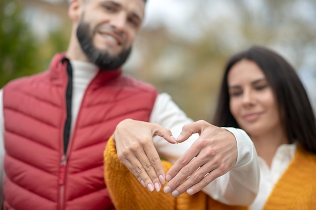 Foto messa a fuoco selettiva della mano a forma di cuore