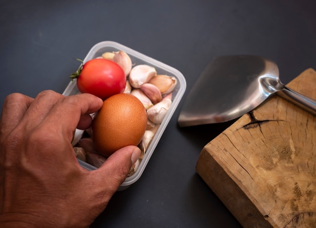 Selective focus of hand held eggs with tomatoes and garlic in a