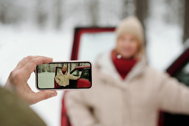 Selective focus on hand of mature man holding smartphone