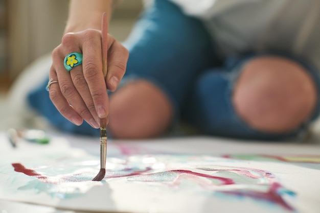 Selective focus of hand of young creative craftswoman with paintbrush