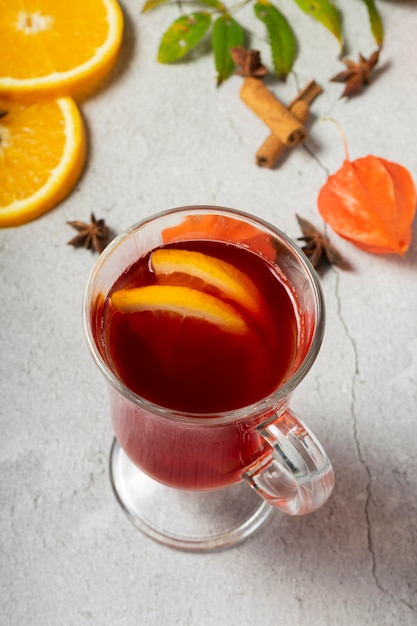 Selective focus, hot drink, warmed red wine with fruit from oranges and apples, with spices of anise and cinnamon