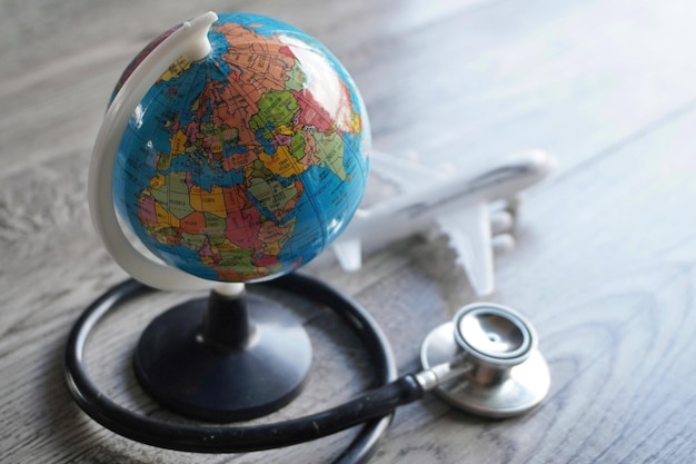 Selective focus image of globe toy plane and stethoscope Medical tourism concept