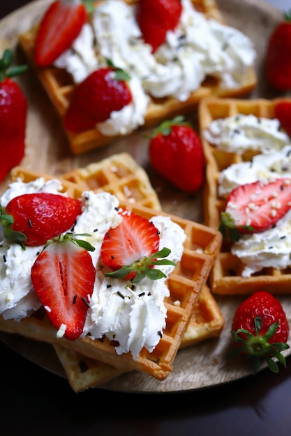 Selective focus macro belgian waffles with strawberries and\
cream