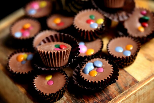 Selective focus Macro Small chocolate candies on a wooden board