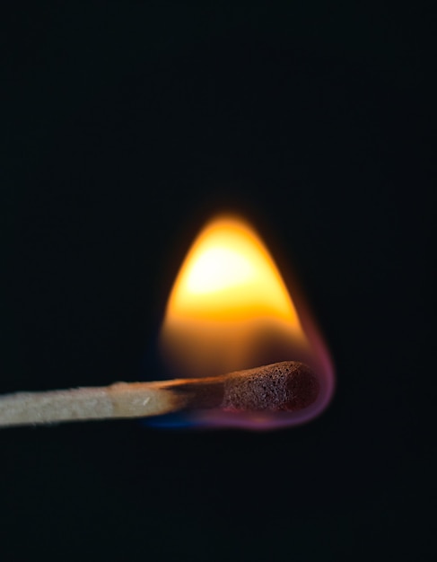 Photo a selective focus of a match on fire on black background