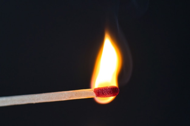 Photo a selective focus of a match on fire on black background