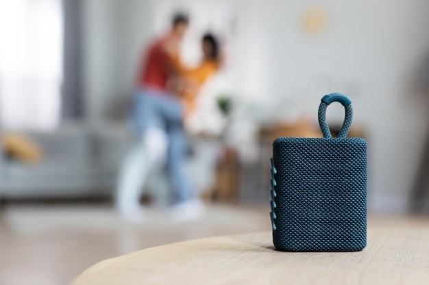 Selective focus on modern gadget portable speaker over dancing lovers