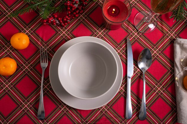 Selective focus. New Year's table setting with a red checkered tablecloth and a high champagne glass. low key. postcard