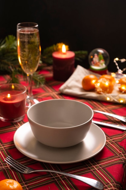 Selective focus new years table setting with a red checkered tablecloth and a high champagne glass l...