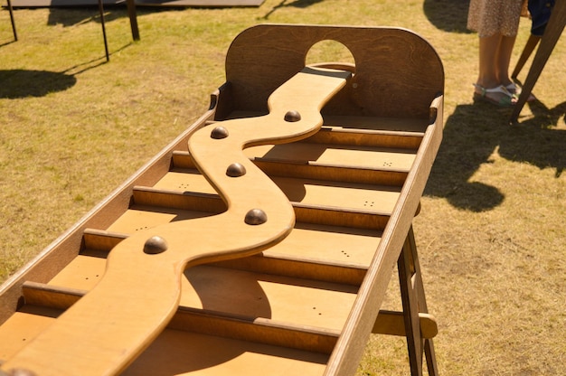 A selective focus of an old wooden game on the outside in which it is necessary to roll the ball on an inclined board