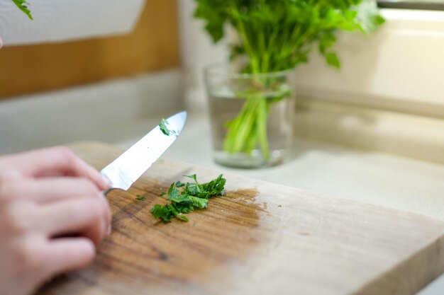 写真 ペルセリーを手で切ることに専念し,ベジタリアンやベガンの食事に調味料を加える