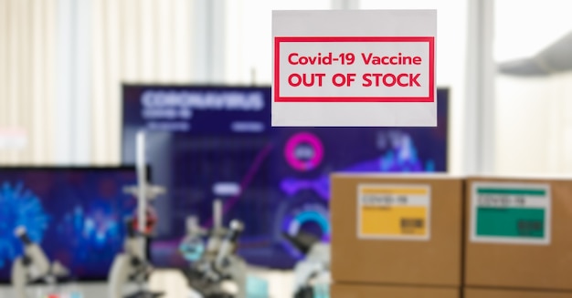 코비드 19 백신이 배경에 분리된 색상 라벨과 현미경이 있는 상자에 포장된 코비드 19 백신에 대한 '재고 없음'에 선택적 초점. Covid 19 예방 접종에 대한 개념입니다.