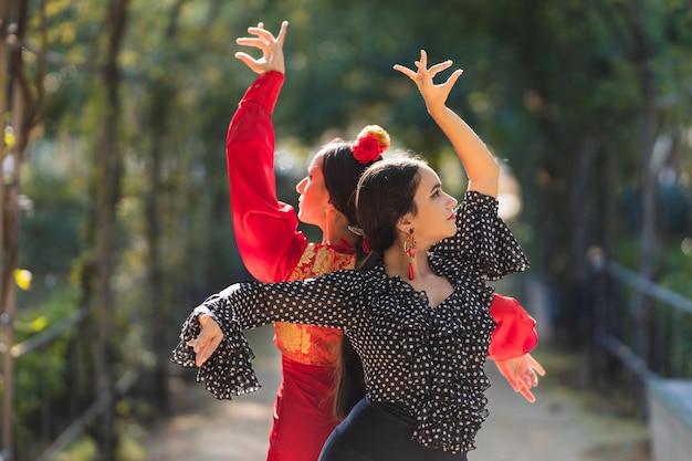 Selective focus on a pair of female flamenco dancers performing a choreography in a park