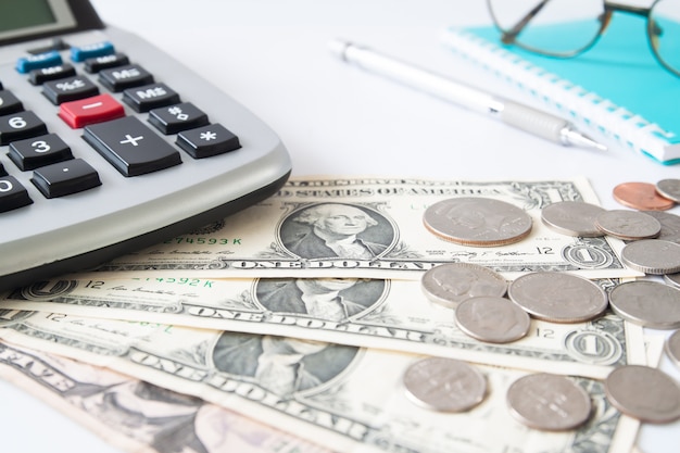 Selective focus on paper currency and calculator on workspace desk