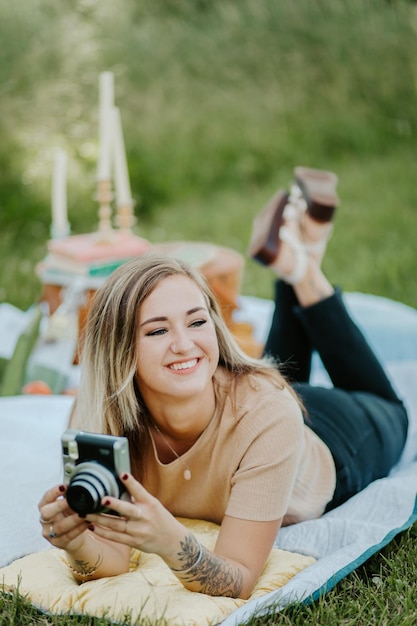 Foto foto selettiva di una donna che sorride mentre tiene in mano una foto di una macchina fotografica d'epoca