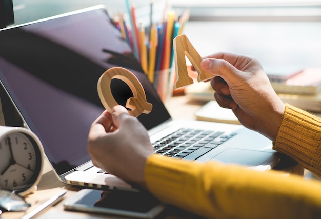 Selective focus Q and A concepts with person holding letters on desk