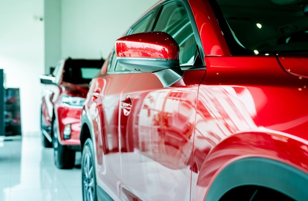 Селективный фокус красный автомобиль, припаркованный в роскошном автосалоне Офис автосалона Новый автомобиль припаркованный автосалон
