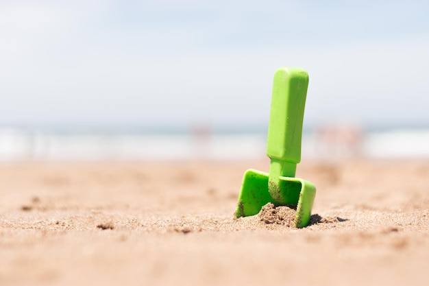 Selective focus of a sand toy on the beach with copy space