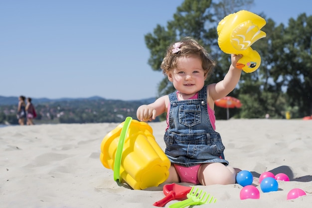 Colpo di messa a fuoco selettiva di un'adorabile bambina che gioca in una spiaggia