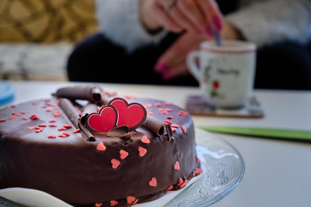 Selective focus shot of a chocolate cake with red hearts