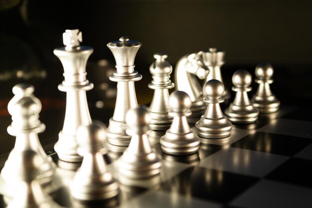 Selective focus shot of decorative silver chess pieces on a checkered board