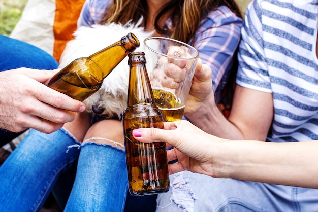 Избирательный снимок группы друзей, чокающихся бутылками пива