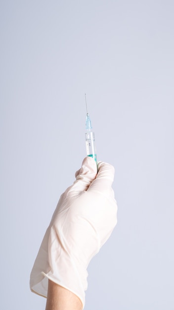 Selective focus shot of a hand holding an injection syringe