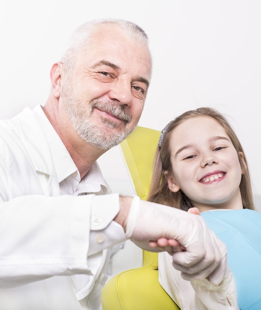 Selective focus shot of a happy little girl as a patient at a dentist's clinic