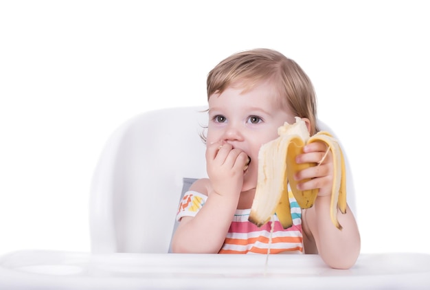 Messa a fuoco selettiva di una bambina felice che mangia una banana