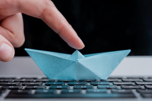 Selective focus shot of a paper boat on the keyboard of a laptop