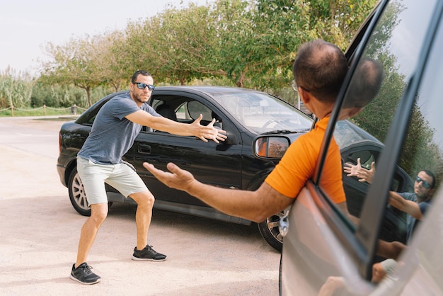 Foto foto selettiva di una persona che discute con il conducente in un incidente stradale