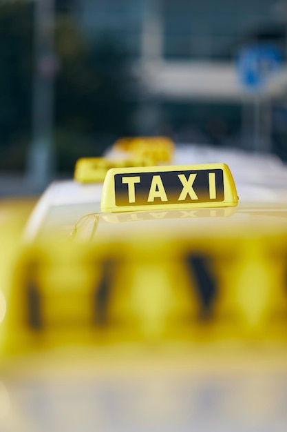 Selective focus on taxi sign on roof car waiting for passenger in city street