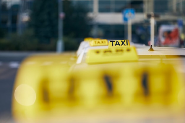 Foto concentramento selettivo sul cartello del taxi sul tetto dell'auto in attesa di passeggeri in una strada della città