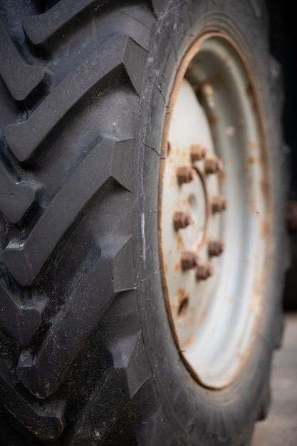 Photo selective focus on the tread of a huge wheel of a belarus tractor strong tire tread on the wheel