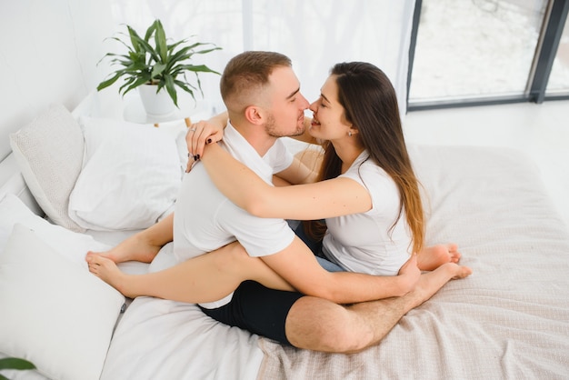 Selective focus of two people in love hugging while sitting in bed