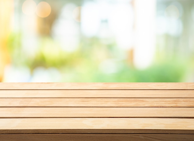 Selective focus.wood table top on blur abstract glass wall background.