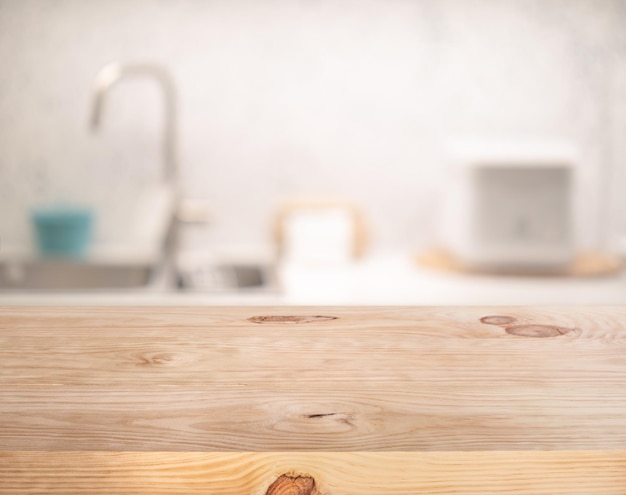 ぼかしキッチンカウンターの背景に選択的なフォーカス/木製のテーブルトップ。モンタージュ製品の表示またはデザインキーの視覚的レイアウト用。