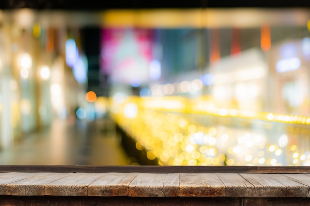 Selective focus of wooden table in front of decorative indoor string lights