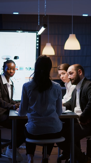 Selective focus of workaholic businesswoman back discussing financial graphs