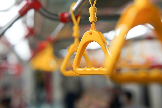 selective focus on yellow hanging handle grip on public transportation such as bus and train