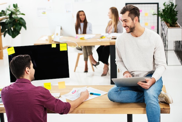 Selective focus of young businessmen at workplace and multicultural businesswomen in office