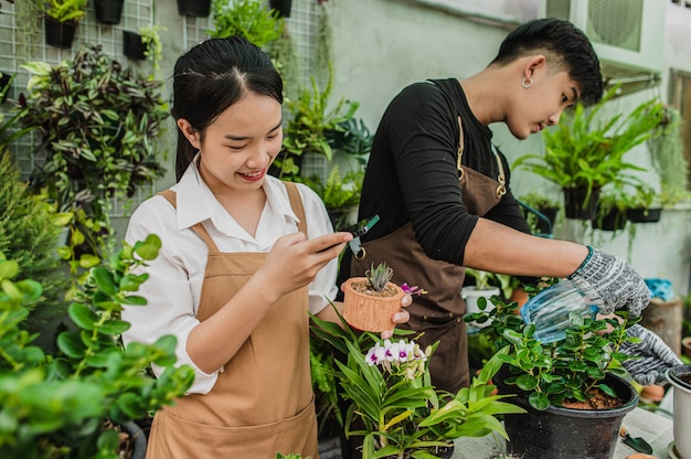 Selective focus, Young woman use smartphone take a photo the cactus, she smile with happy