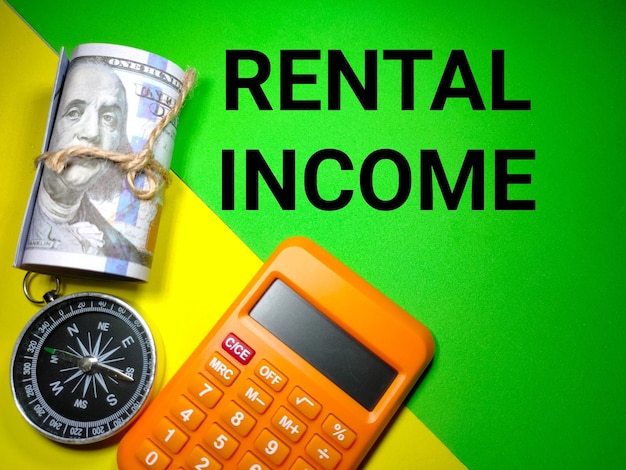 Selective focusBanknotecompass 및 텍스트 RENTAL INCOME이 있는 계산기