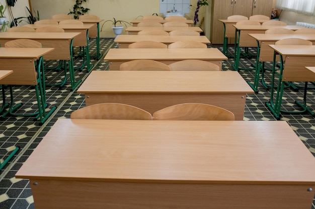 Selective soft and blur focusold wooden row lecture chairs in classroom in poor schoolstudy room without studentconcept for education