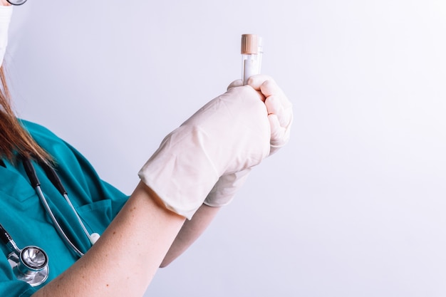 Selective view of hospital female doctor hands holding some\
vials for urine or blood point concept tests in hospital urine\
tests blood tests